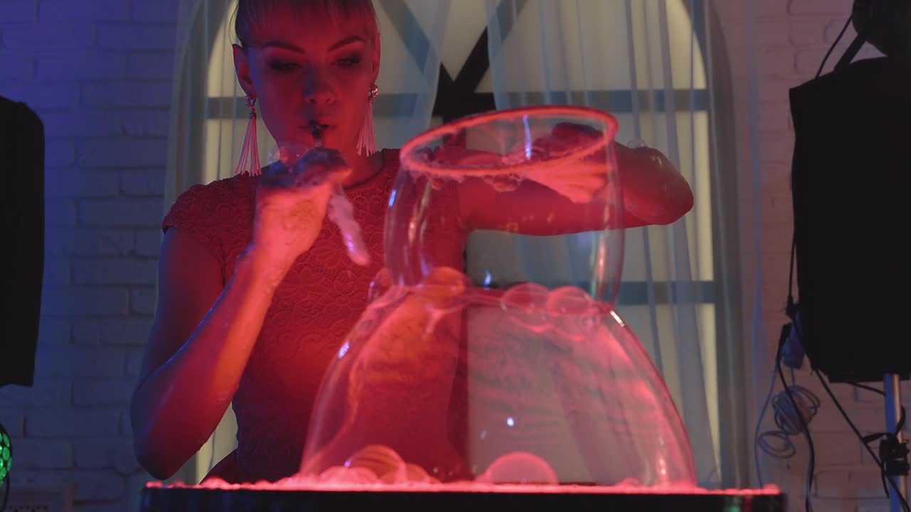 chica linda infla dos enormes burbujas de jabón y juega con ellos hace un espectáculo de primer plano