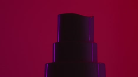 dosing canister of cosmetic cream spinning on red background