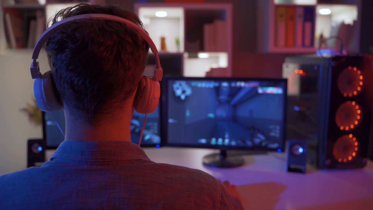 A young man playing a video game inside a room.