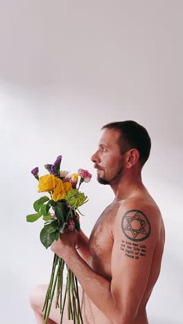 man with flowers, eyes covered, artistic portrait