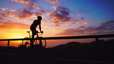 silhouette slow motion reveals the athlete cycling on a mountain serpentine, appreciating the island's view, epitomizing a commitment to a healthy lifestyle at sunset