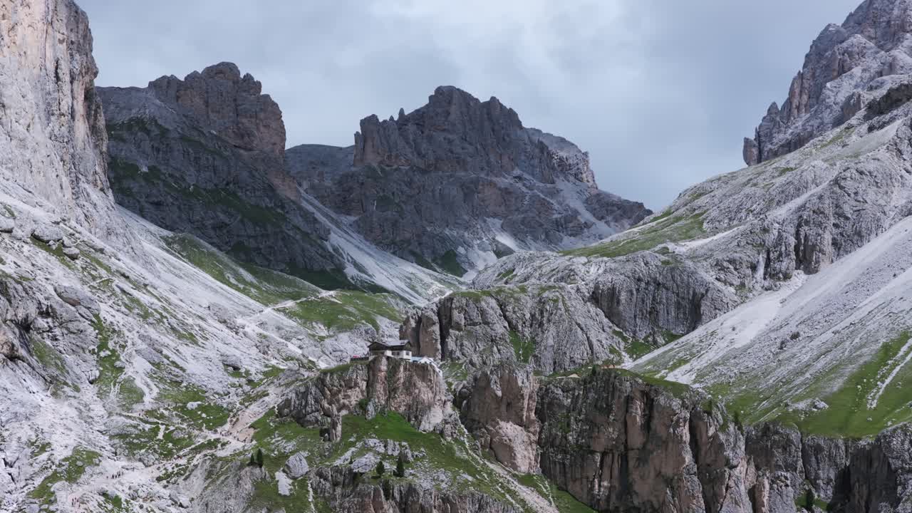 Re Alberto mountain hut nestled in dramatic landscape of Vajolet Towers, Dolomites, Italy. Aerial drone panoramic view