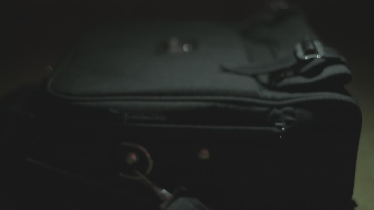 Person packing a black bag at night