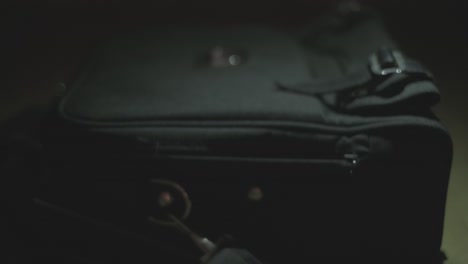 person packing a black bag at night