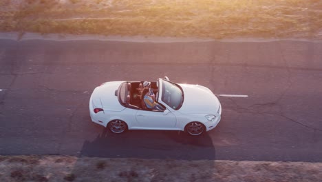 una pareja disfrutando de un pintoresco viaje en un descapotable blanco