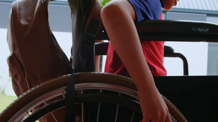 Side view of disabled African American schoolboy moving his wheelchair in school corridor 4k