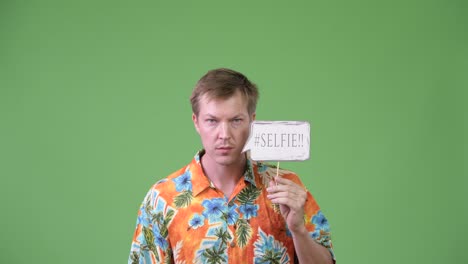 young handsome tourist man screaming with selfie paper sign