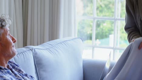 senior couple using laptop on sofa 4k