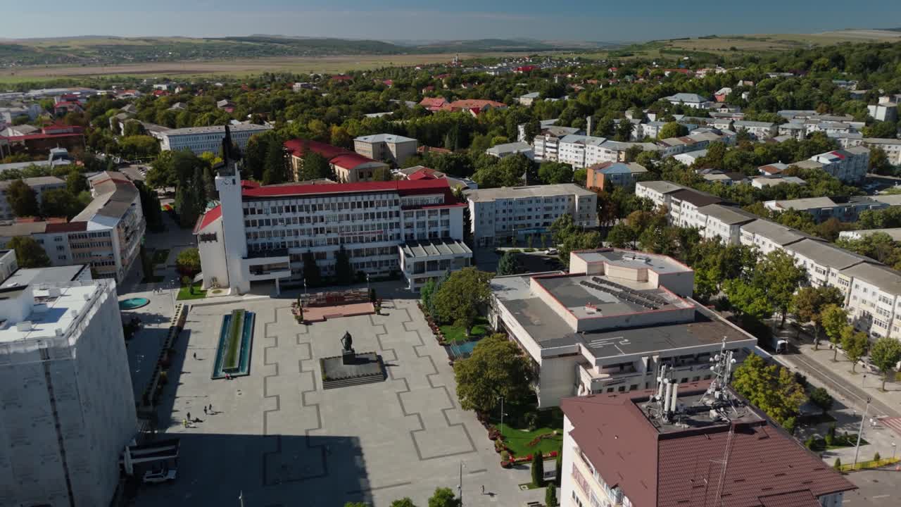 Sunny aerial view of town plaza with surrounding greenery