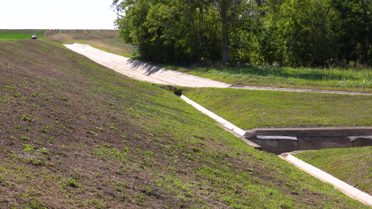 Concrete channels guiding excess water from a rural field, showing drainage engineering