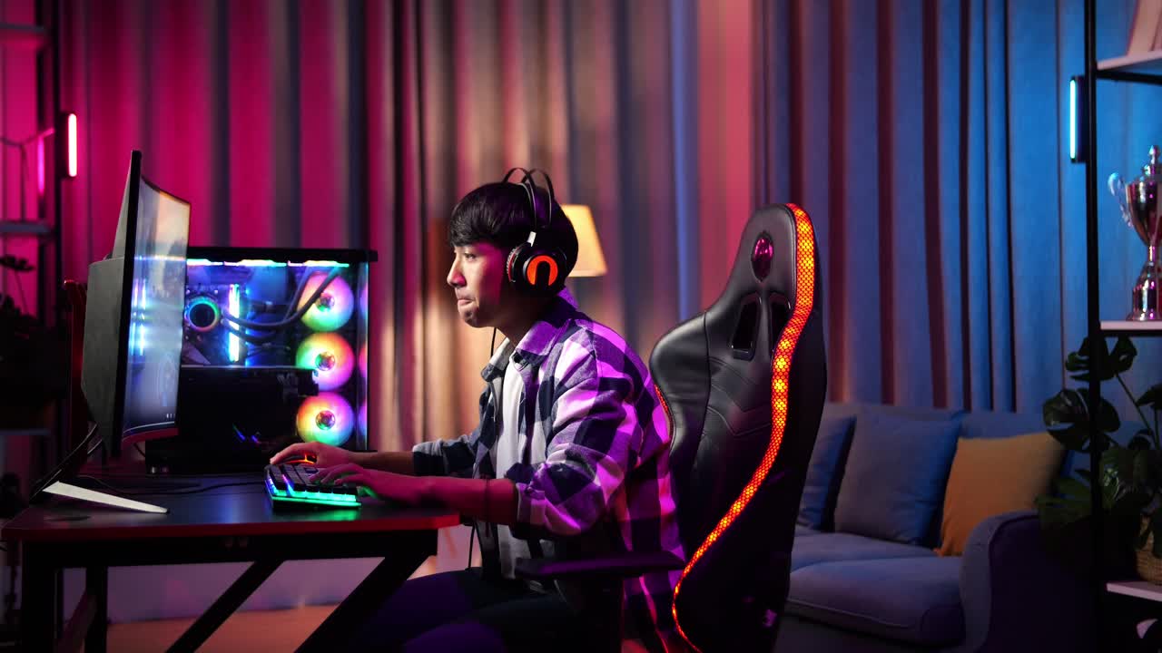Gamer adolescente asiatico serio che gioca a un videogioco al computer