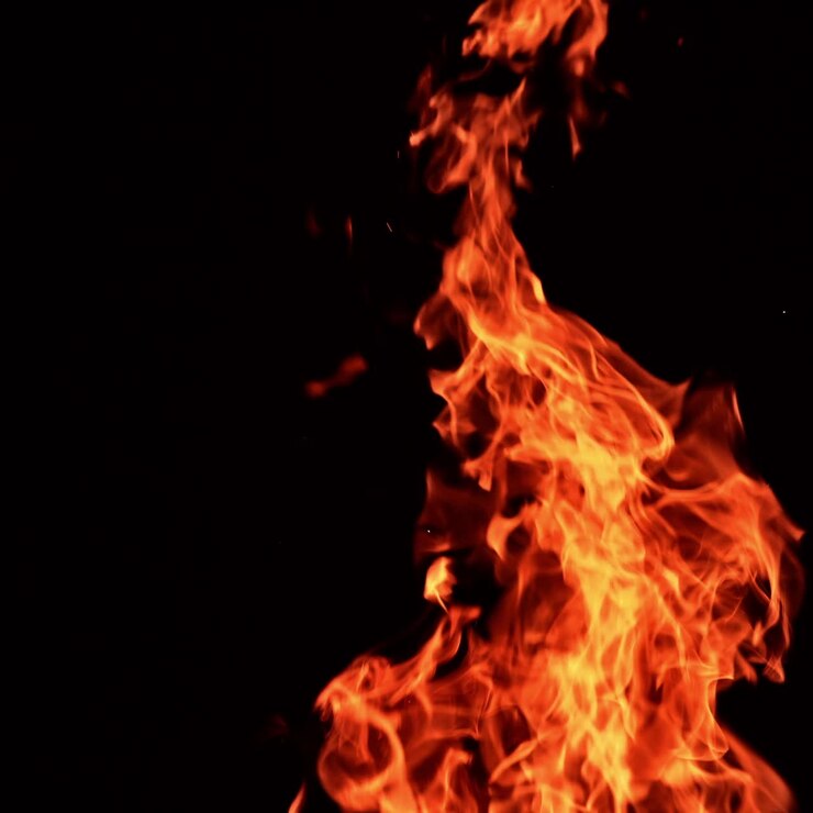 Fiamma rossa incandescente che si innalza nell'aria in orizzontale e in verticale. Splendida fiamma che danza nell'oscurità