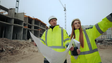 female-building-inspector-and-foreman-are-discussing-construction-plan-in-building-site