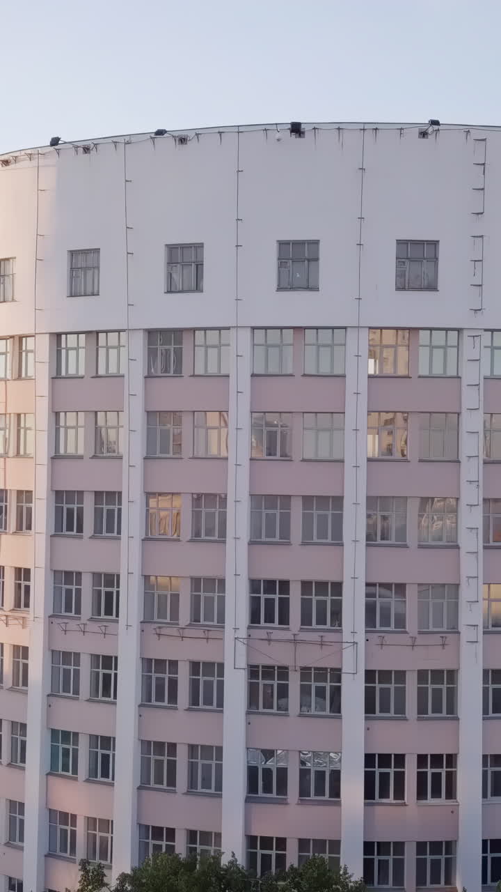 edificio curvo de varios pisos con fachada rosa y blanca