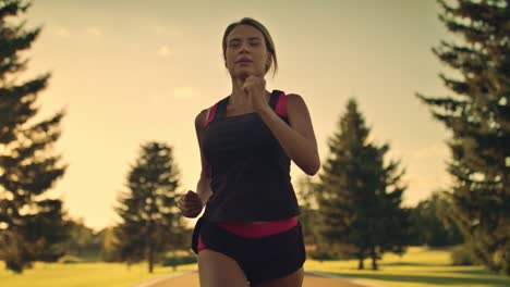 sport woman running at sunset. female runner at outdoor workout in park