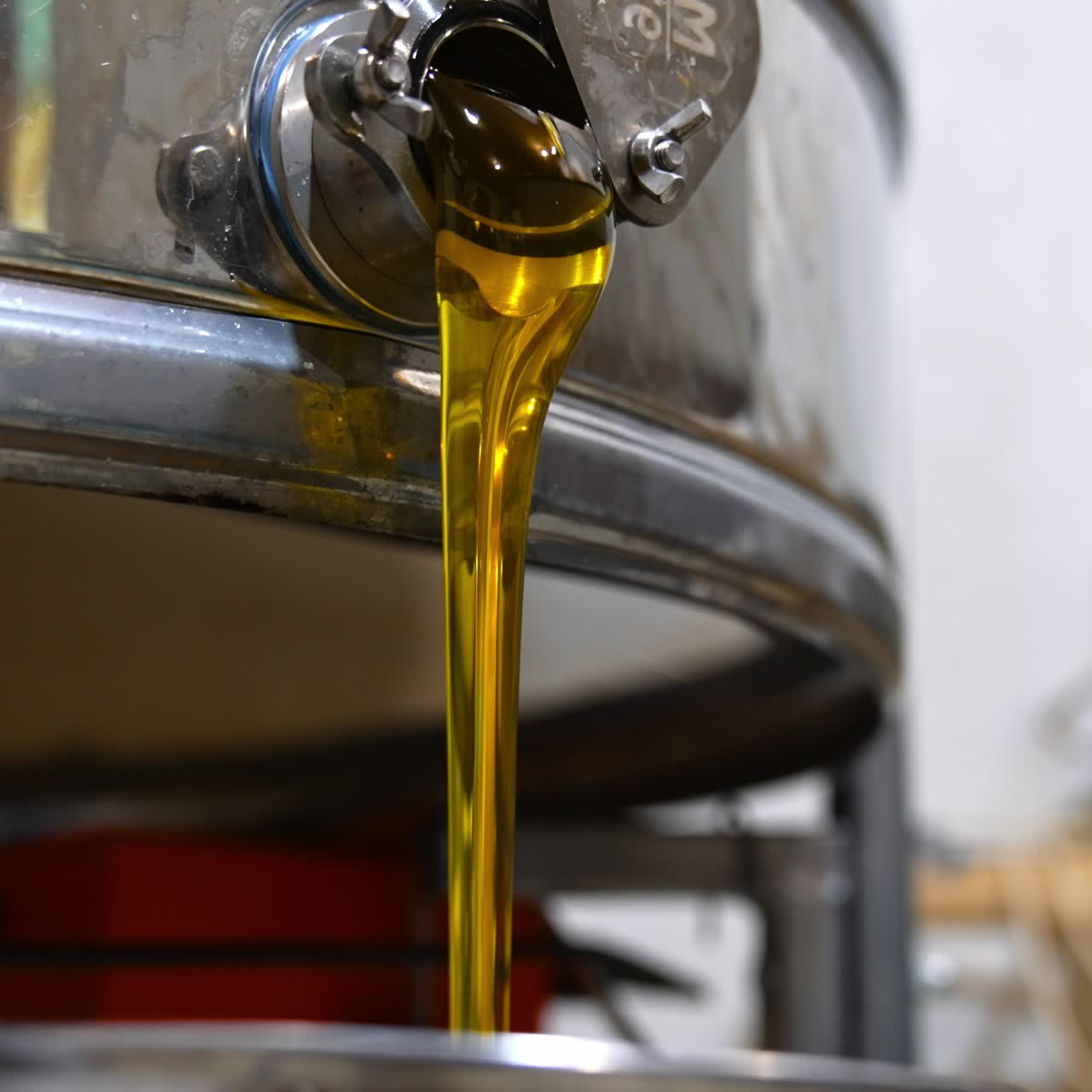 Honey freshly picked from frames and flowing from centrifuge machine. Close up. Process of gathering honey at apiary