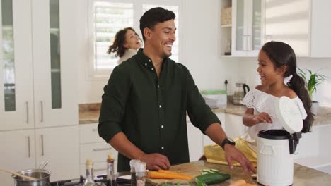 hispanic parents and daughter cooking and teaching segregating bio trash