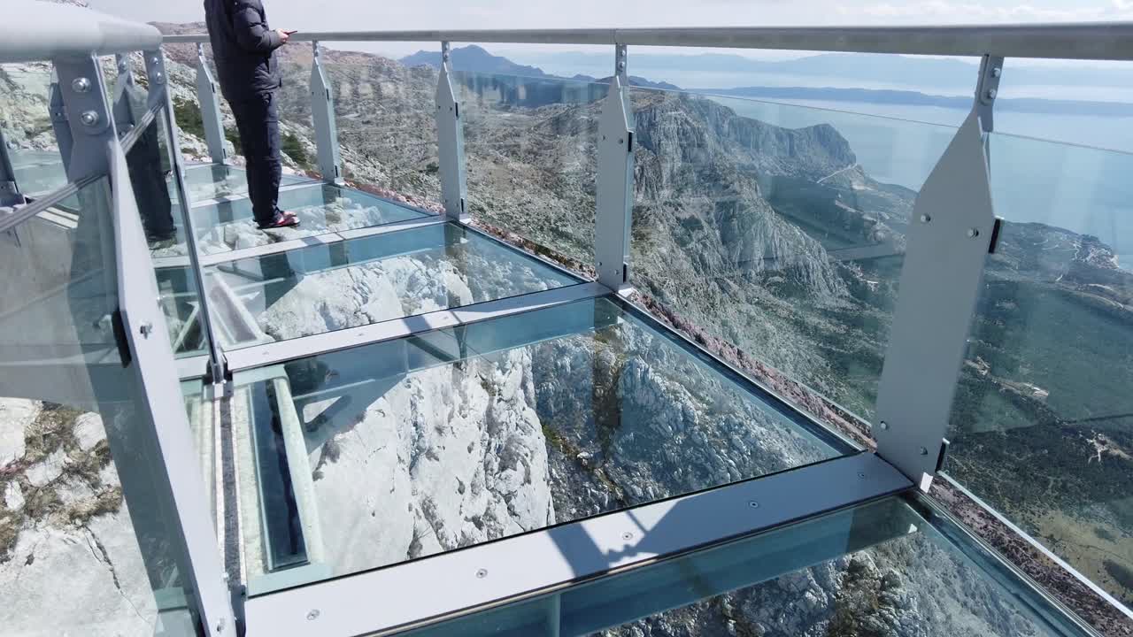 Point of view of person walking on glass viewing deck. Vertigo and acrophobia concept