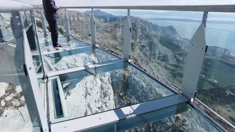 point of view of person walking on glass viewing deck. vertigo and acrophobia concept