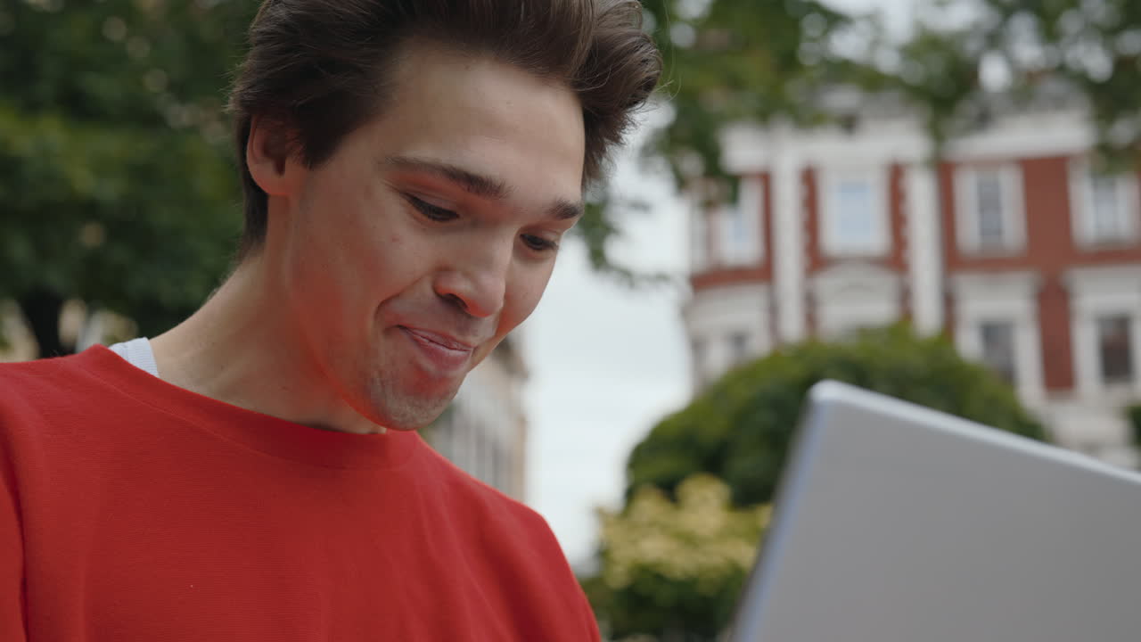 Uomo che festeggia mentre guarda un tablet all'aperto
