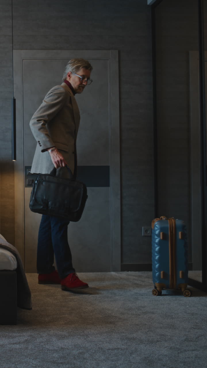Man in suit with luggage in hotel room