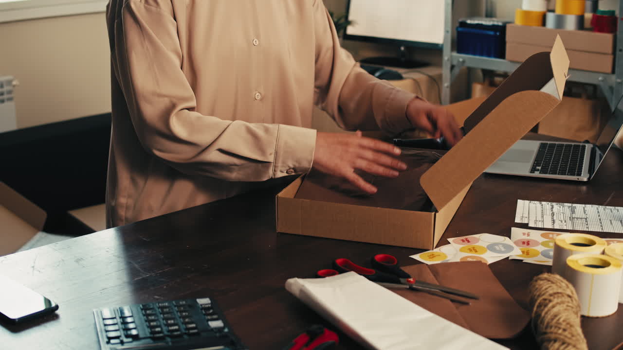 E-commerce storage shop, woman packing goods and clothes for second hand delivery market, dedicated Packaging and Shipping Workspace with Supplies and Technology for efficiency, online sales.