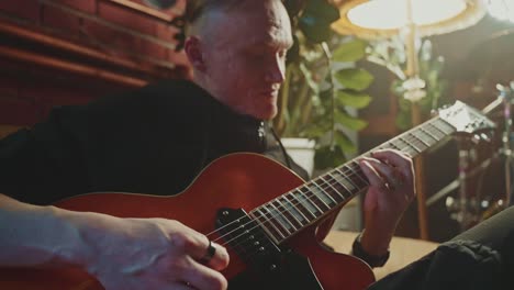 man playing jazz guitar at home