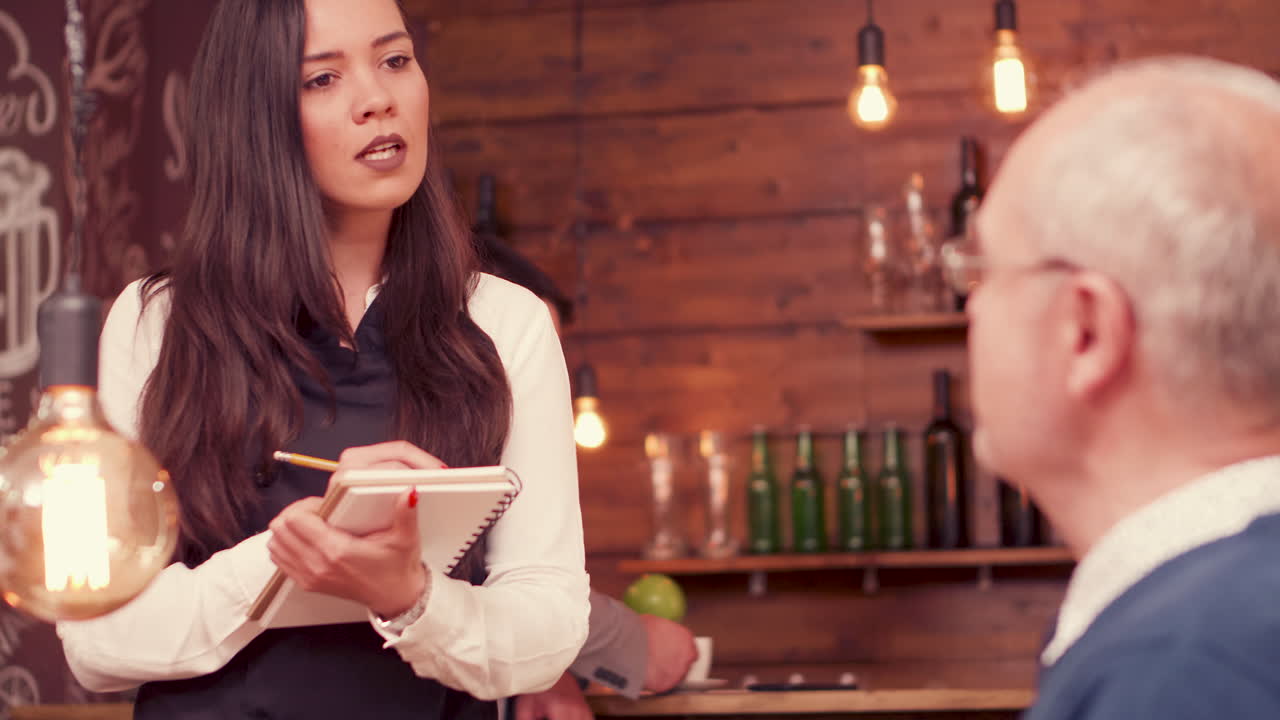 Waitress taking order from customer at bar