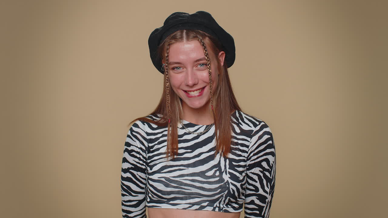 Smiling playful happy girl blinking eye, looking at camera with smile, winking, flirting, optimism