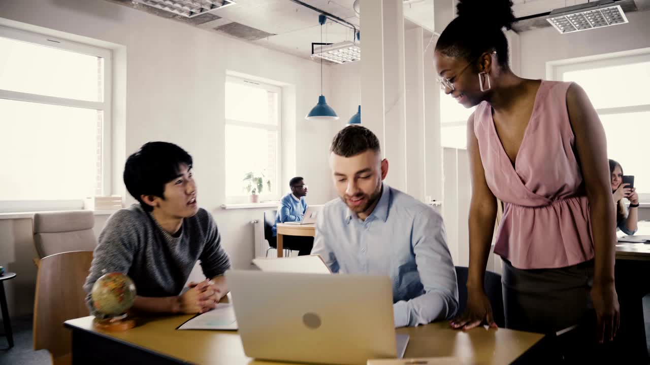 a câmera segue uma treinadora de negócios afro-americana entrar no escritório, motivar e inspirar trabalhadores multiétnicos equipe 4k