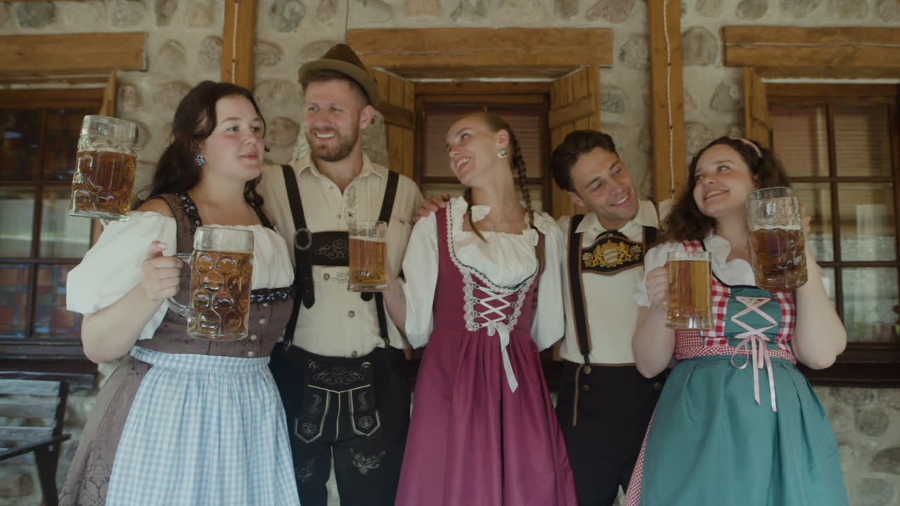 Group of people in traditional Bavarian clothing celebrating Oktoberfest with beer