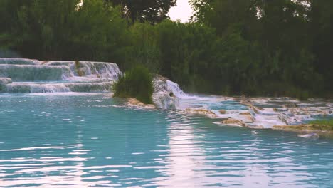 cinemagraph en el baño de aguas termales geotérmicas y cascadas en saturnia, toscana, italia, cerca de siena y grosseto al amanecer. cascate del mulino, lugar pintoresco y famoso con agua caliente de vapor azul en 4k uhd con niebla.