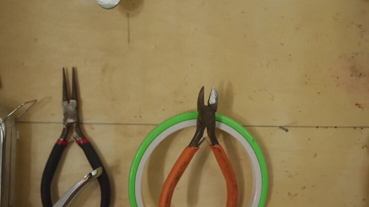 Diverse tools and belts hanging on wall in leather workshop