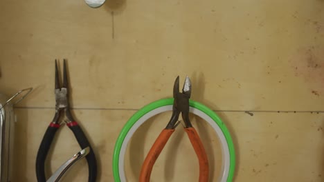 diversas herramientas y cinturones colgados en la pared en el taller de cuero