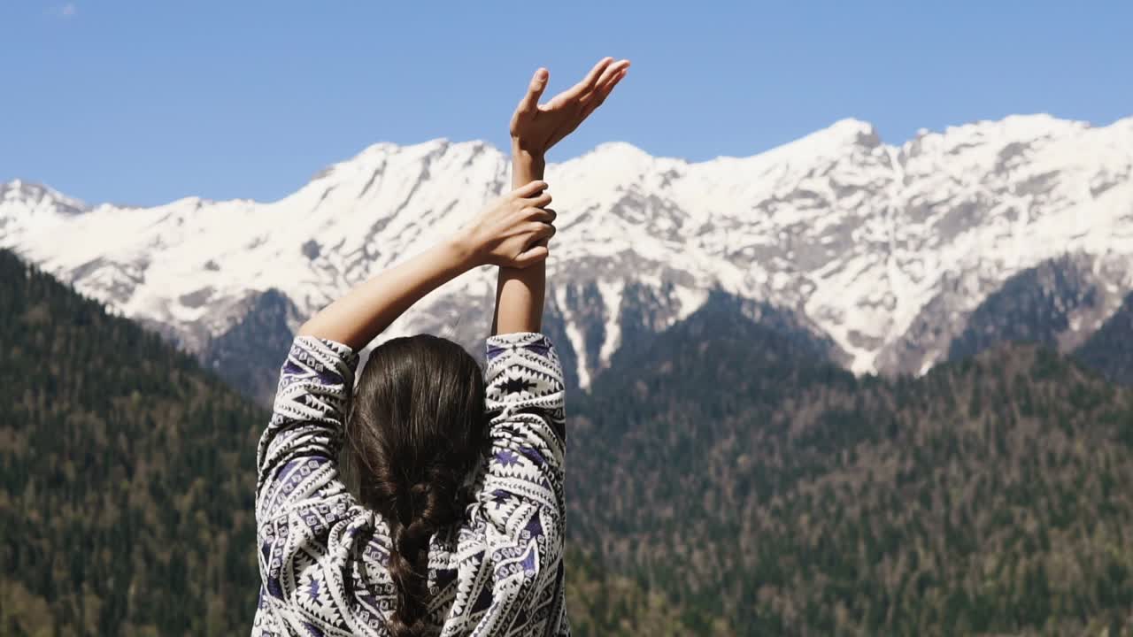 mujer disfrutando de una vista de las montañas cubiertas de nieve