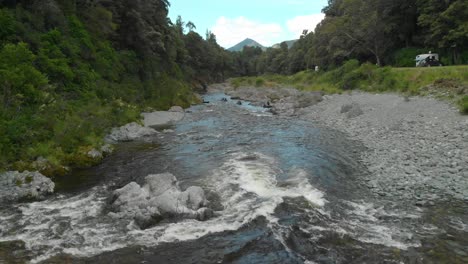 Overhead-Aerial-Drone-of-Pelorus-river-with-white-rapids-and-rock-boulders-and-people-kayaking-in-background
