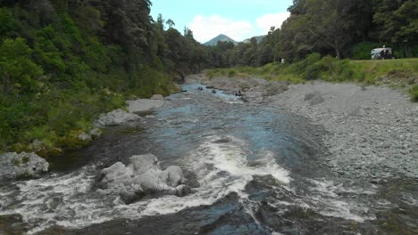 overhead aerial drone of pelorus river with white rapids and rock boulders and people kayaking in background