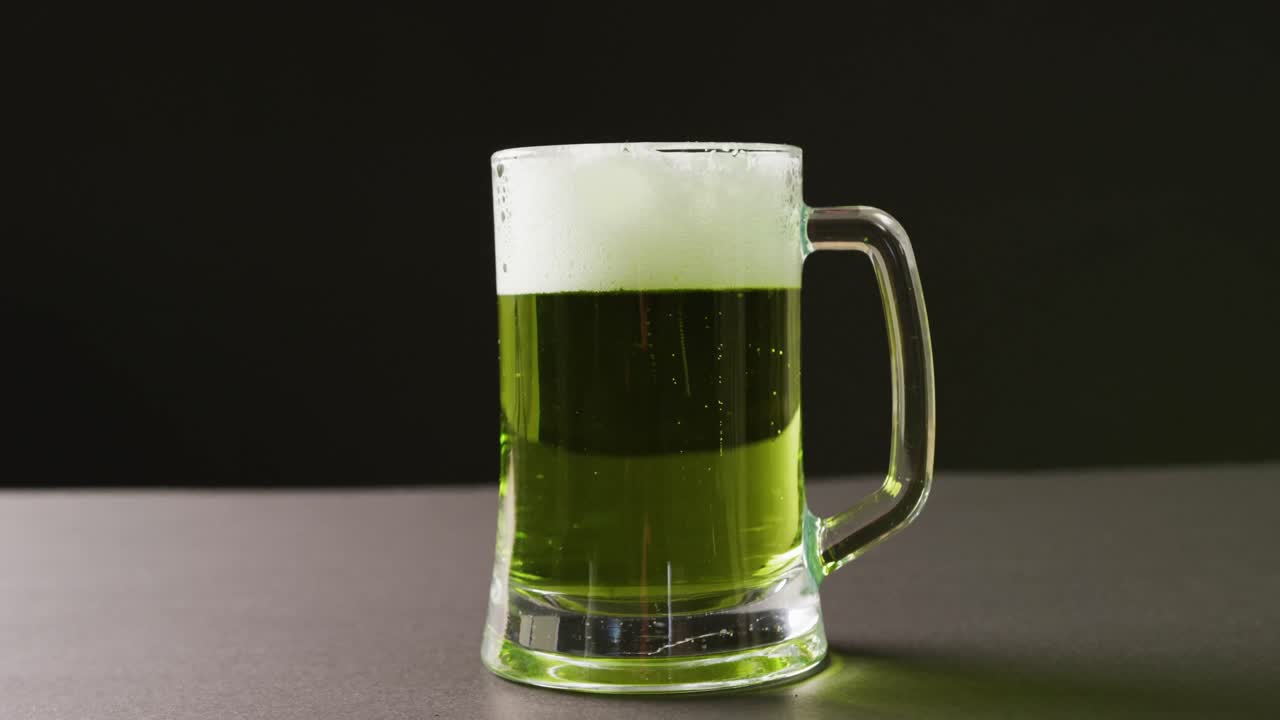 video del día de san patricio un vaso de cerveza verde con espacio de copia sobre un fondo gris.