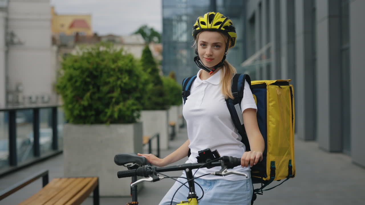 Woman Food Delivery Person on Bike in Urban Setting
