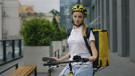 woman food delivery person on bike in urban setting