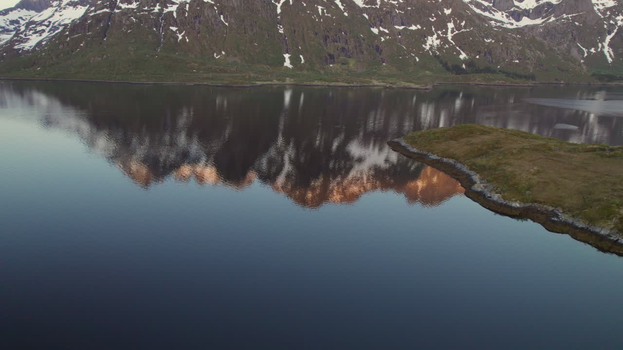 Revealing large mountain reflected in the Austnesfjorden at golden hour