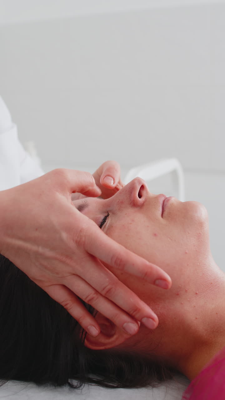 코스메톨로지 테라피스트는 여성이 휴식을 취하는 스파에서 손으로 얼굴 마사지를 할 수 있습니다.