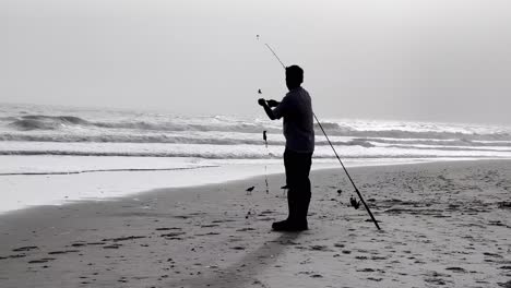 Pescador-Frente-A-La-Costa-De-Nc,-Costa-De-Carolina-Del-Norte