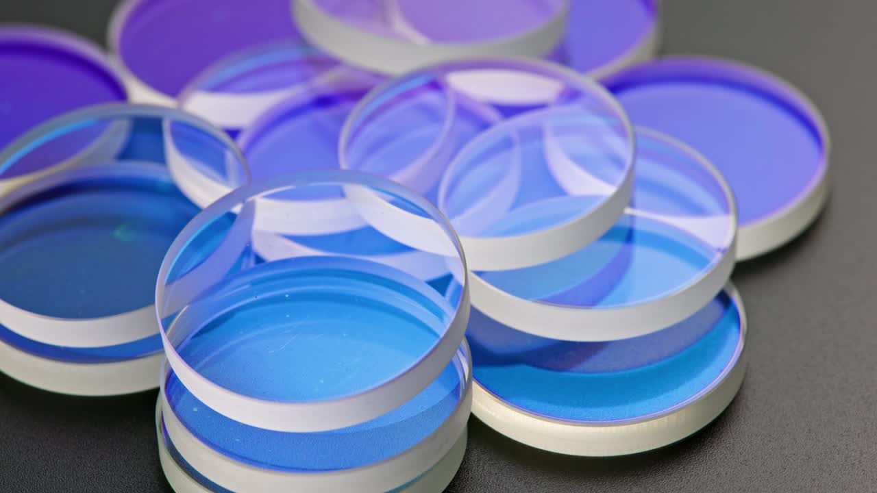 검은색 표면에 쌓인 평평한 둥근 유리 조각의 전체 프레임 루프 회전 배경