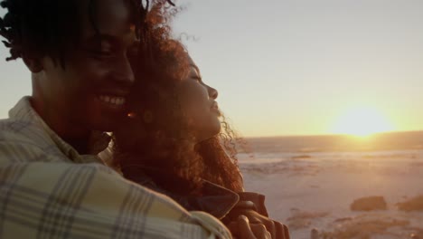 hombre abrazando a una mujer en la playa durante la puesta de sol 4k
