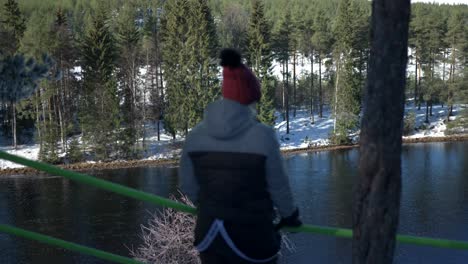 women standing next to river, cold winter day in boreal nordic landscape, medium