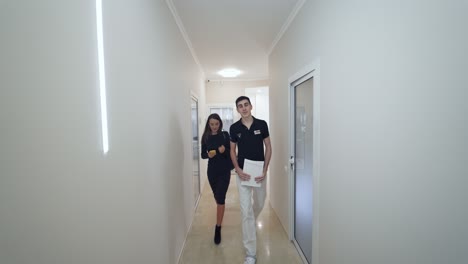 patient walking in corridor. woman walking through hospital hallway