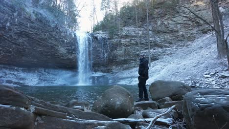 Mann,-Der-Während-Des-Wintermorgens-In-Georgia-Am-Wasserfall-Fotografiert