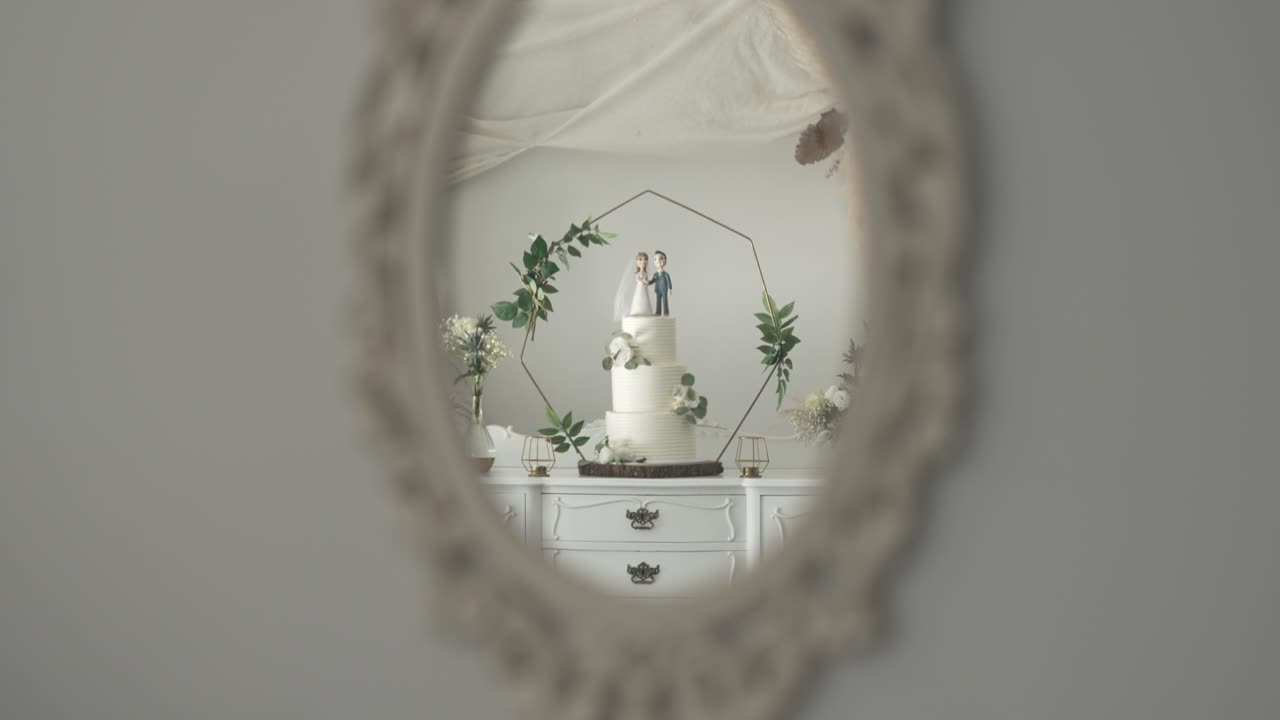 Wedding cake with figurines reflected in vintage mirror, soft, elegant decor setting