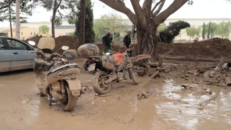 motorcycles swept away by floods, surrounded by mud and storm debris